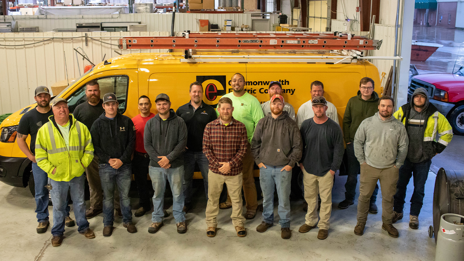 Commonwealth Electric's Lincoln Service team stands in front of a yellow service van.