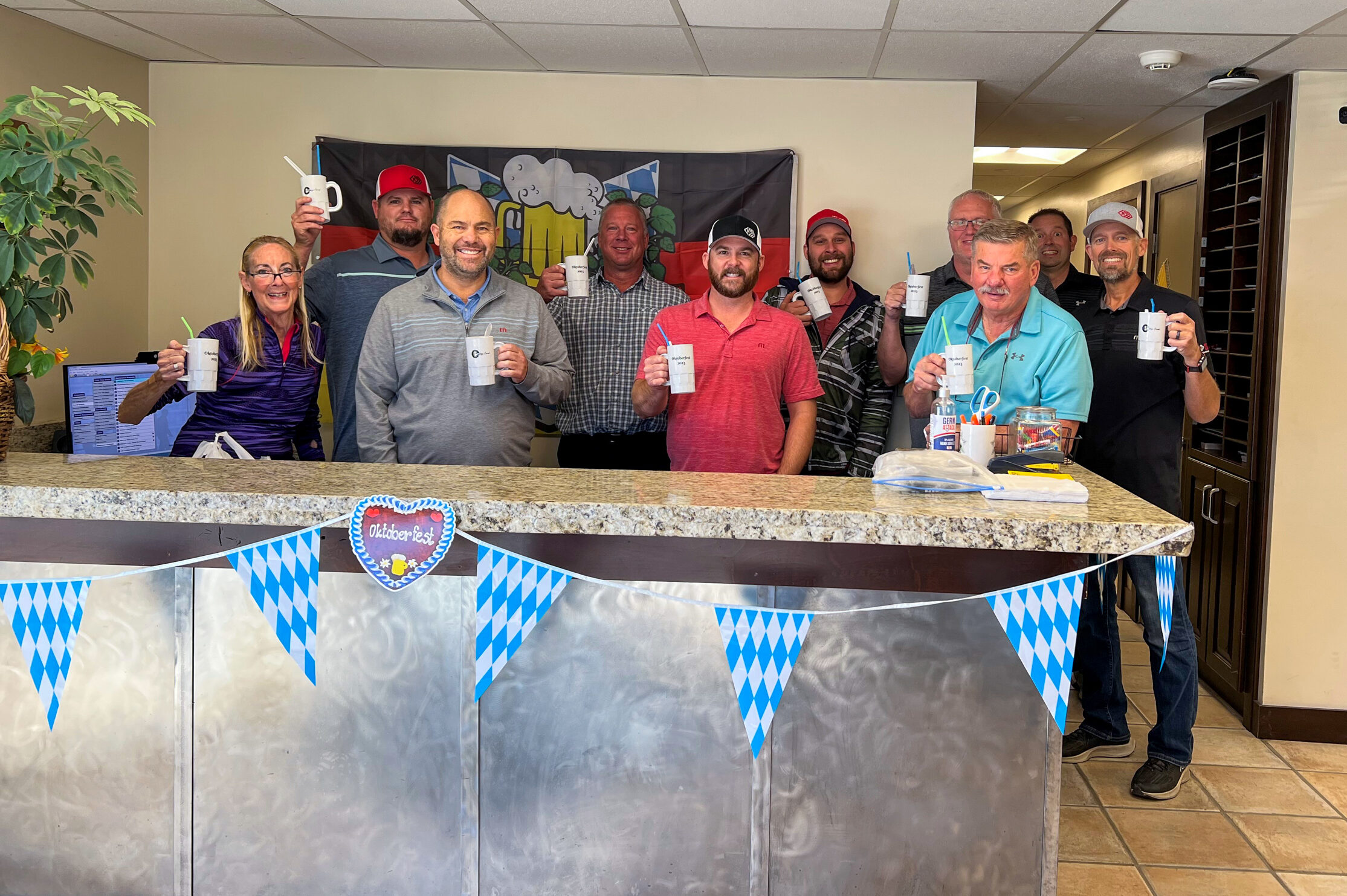 Rydalch Electric employees hold mugs for their Oktoberfest celebration