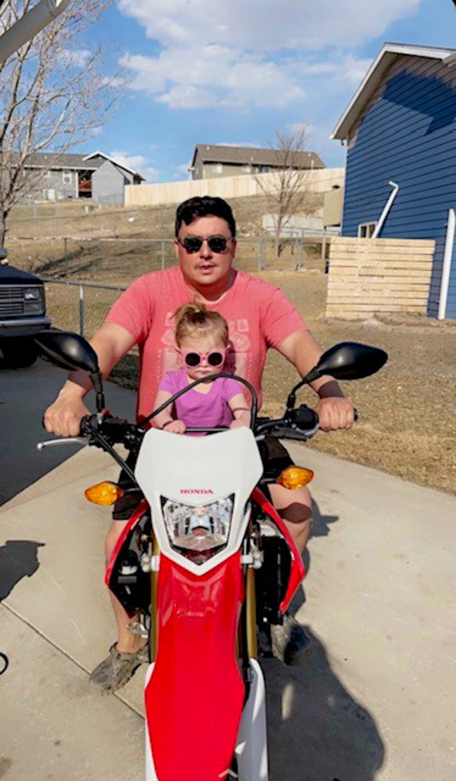 Dan Ramsdell takes a photo with his daughter on a motorcycle.