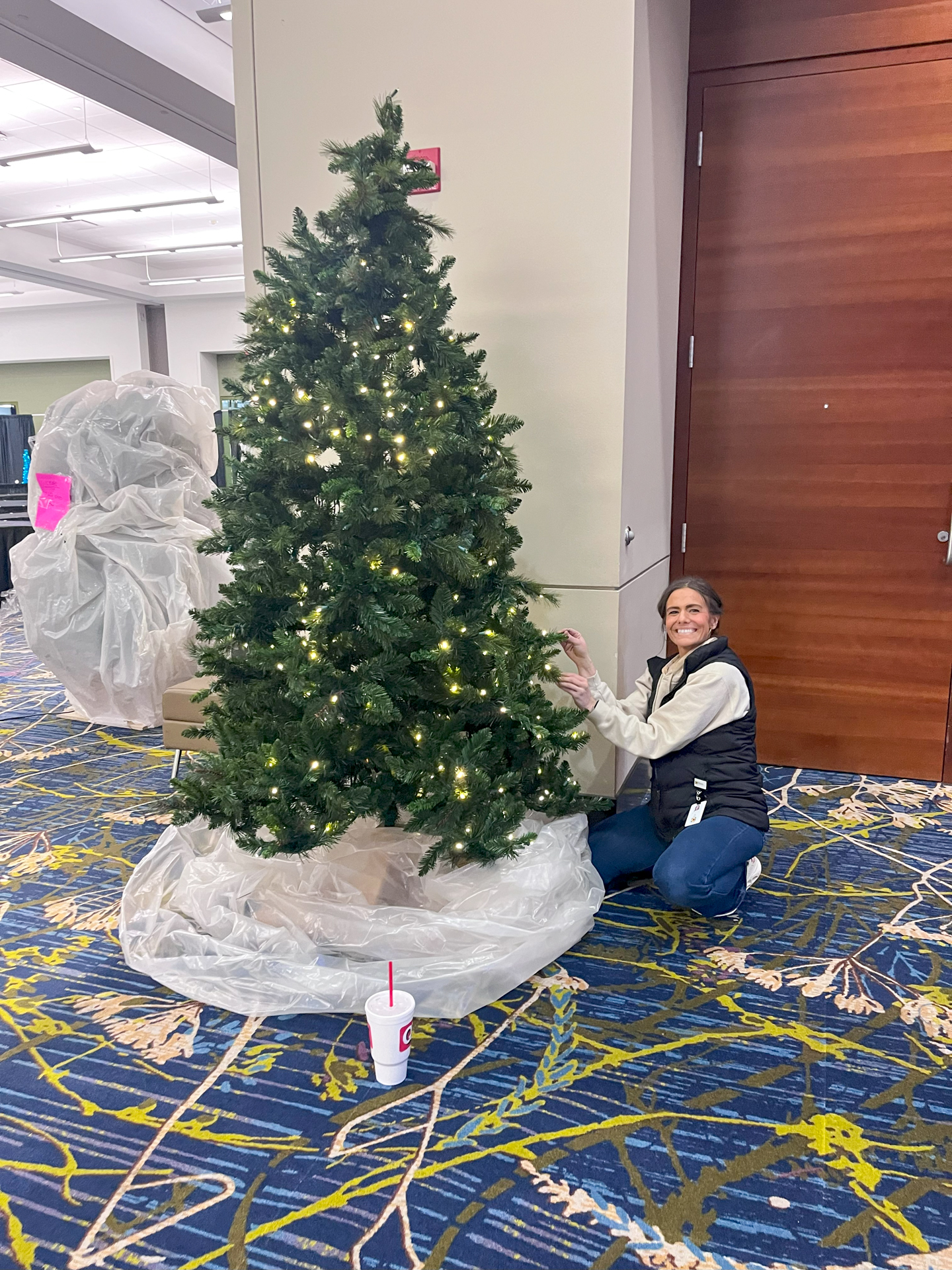 Administrative Assistant Liz Duffy sets up and fluffs a tree.