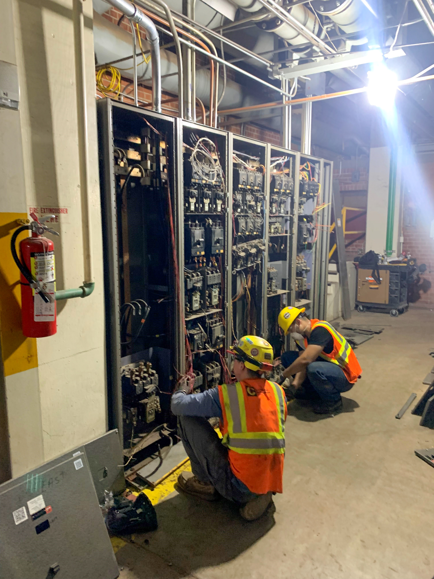 A picture of two commonwealth employees installing switchboards.